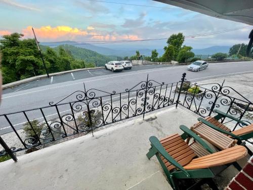 a balcony with two benches and a road with cars at Skyline Village Inn in Spruce Pine