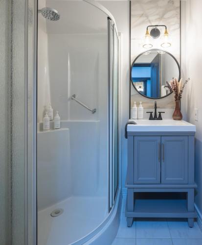 a bathroom with a blue sink and a shower at Malia Spa and Resort inc in Lamèque