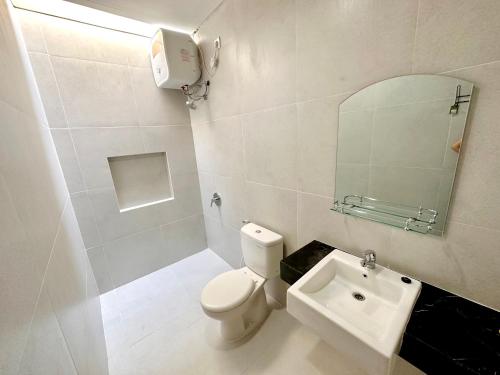 a bathroom with a toilet and a sink and a mirror at Charming 4BR House in Northwest Park, West Surabaya by Le Ciel Hospitality in Surabaya