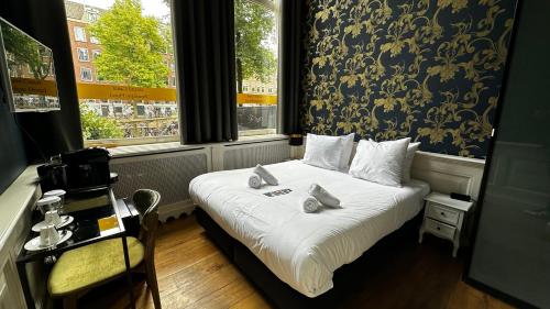 a bedroom with a bed with two stuffed animals on it at Grand Canal Boutique Hotel in Amsterdam