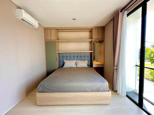 a small bedroom with a bed and a window at Charming 4BR House in Northwest Park, West Surabaya by Le Ciel Hospitality in Surabaya