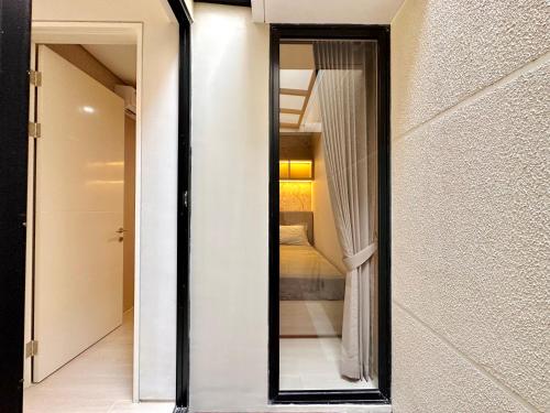 a mirror on a wall next to a bedroom at Charming 4BR House in Northwest Park, West Surabaya by Le Ciel Hospitality in Surabaya