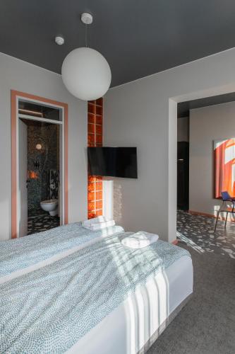 a bedroom with a large bed and a flat screen tv at Resume apartments in Kaunas