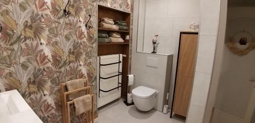 a bathroom with a toilet and a flowery wallpaper at Gîte Guldangel in Hirsingue