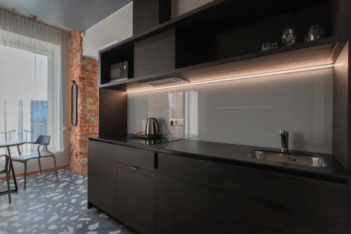 a kitchen with a black counter and a sink at Resume apartments in Kaunas