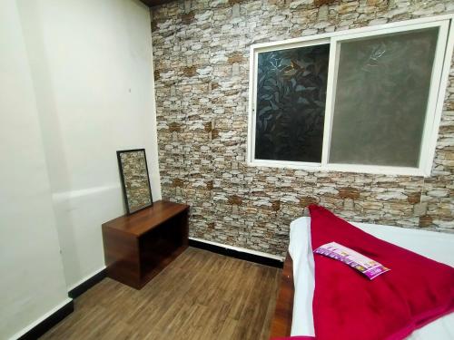 a living room with a brick wall and a window at junagadh places in Ujjain