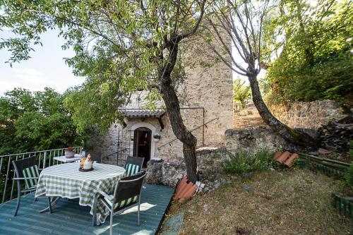 a table and chairs on a deck with a tree at Cozy chalet "Da Silvio e Bruna" in Santo Stefano di Sessanio