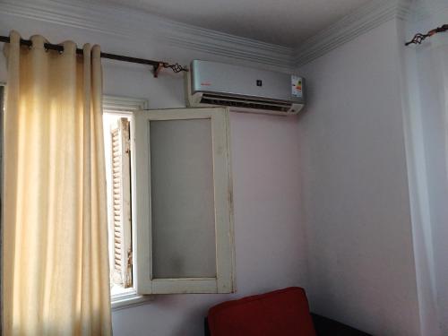 a room with a window and a air conditioner on the wall at A room in an apartment in Nasr City, Cairo, near Azhar university , 15 minutes from Cairo Airport,غرفة بشقة بمدينة نصر بالقاهرة بالحي الثامن 15 دقيقة من مطار القاهرة و 7 دقيقة من معهد الفجر و 12 دقيقة لمعهد ابانة لتعليم اللغة العربية و 26 دقيقة لوسط البلد in Cairo