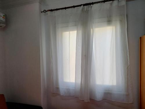 a window with white curtains in a room at A room in an apartment in Nasr City, Cairo, near Azhar university , 15 minutes from Cairo Airport,غرفة بشقة بمدينة نصر بالقاهرة بالحي الثامن 15 دقيقة من مطار القاهرة و 7 دقيقة من معهد الفجر و 12 دقيقة لمعهد ابانة لتعليم اللغة العربية و 26 دقيقة لوسط البلد in Cairo