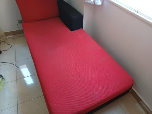 a red bench sitting next to a wall at A room in an apartment in Nasr City, Cairo, near Azhar university , 15 minutes from Cairo Airport,غرفة بشقة بمدينة نصر بالقاهرة بالحي الثامن 15 دقيقة من مطار القاهرة و 7 دقيقة من معهد الفجر و 12 دقيقة لمعهد ابانة لتعليم اللغة العربية و 26 دقيقة لوسط البلد in Cairo