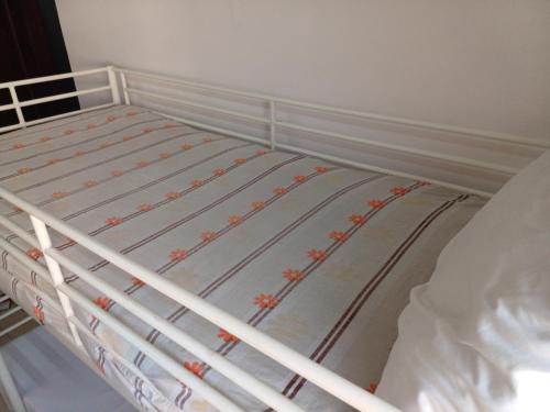 a white bunk bed with flowers on the mattress at A room in an apartment in Nasr City, Cairo, near Azhar university , 15 minutes from Cairo Airport,غرفة بشقة بمدينة نصر بالقاهرة بالحي الثامن 15 دقيقة من مطار القاهرة و 7 دقيقة من معهد الفجر و 12 دقيقة لمعهد ابانة لتعليم اللغة العربية و 26 دقيقة لوسط البلد in Cairo