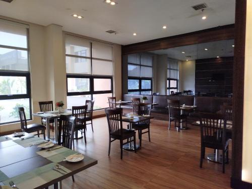 a dining room with tables and chairs and windows at Agulu Lake Resort and Conference Centre in Ekwulobia