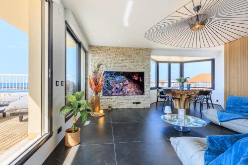 un salon avec un canapé et une cheminée dans l'établissement Appartement Horizon Bleu - 4 étoiles - Welkeys, à Capbreton