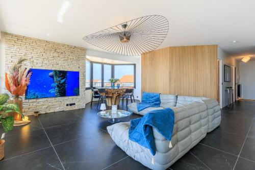 un salon avec un canapé et une télévision dans l'établissement Appartement Horizon Bleu - 4 étoiles - Welkeys, à Capbreton