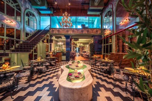 an empty restaurant with tables and chairs and a chandelier at Connaught Royale Delhi in New Delhi