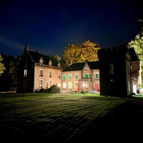 a large house at night with its lights on at Hostellerie Du Château Les Muids in La Ferté-Saint-Aubin