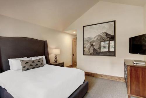 a bedroom with a white bed and a television at 4 Bedroom Luxury Townhome In Lionshead Village in Vail