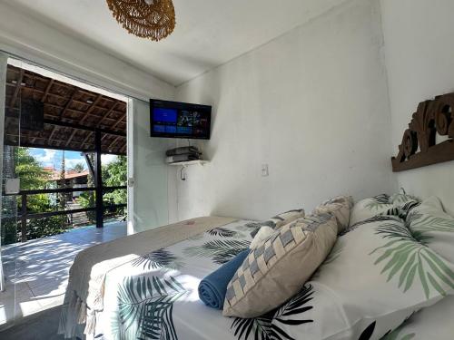 a bedroom with a bed with a television on the wall at Suítes - Village Capixaba in Gravatá