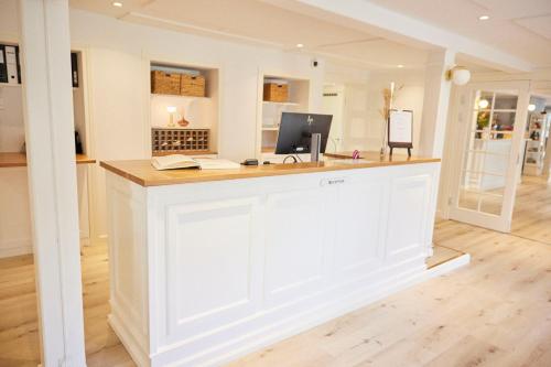 a kitchen with a counter with a computer on it at Hjorths Badehotel in Kandestederne