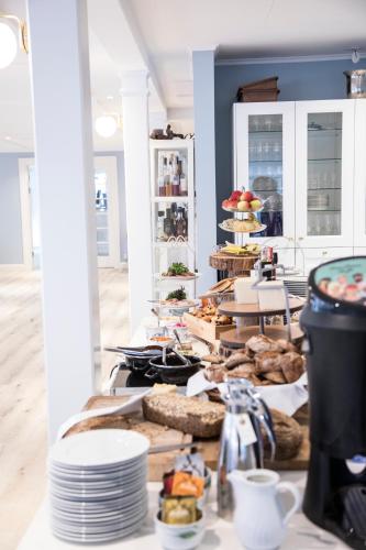 a table with plates of food on top at Hjorths Badehotel in Kandestederne