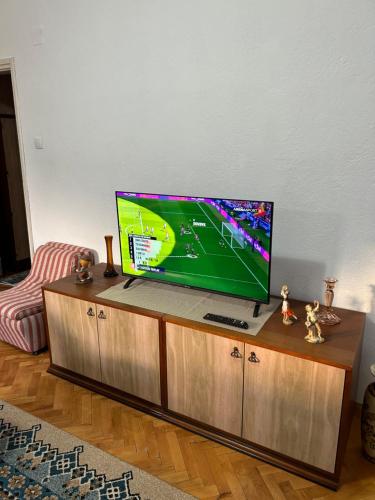 telewizor z płaskim ekranem umieszczony na szczycie centrum rozrywki w obiekcie Vintage Apartman w mieście Strumica