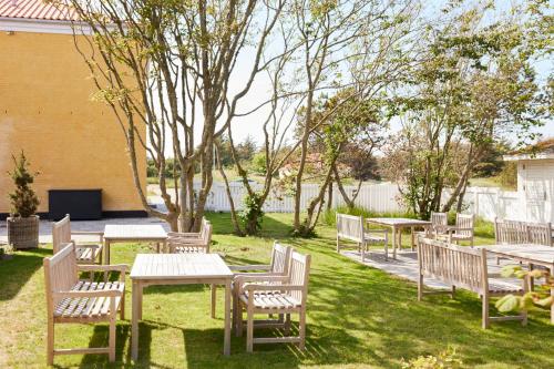 a group of tables and chairs in a yard at Hjorths Badehotel in Kandestederne
