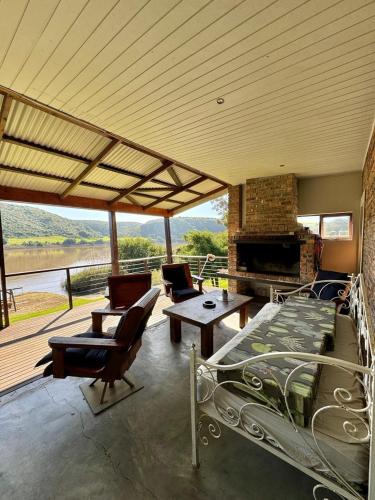 MalgasにあるBreede Getawayのベッド、椅子、暖炉が備わる客室です。