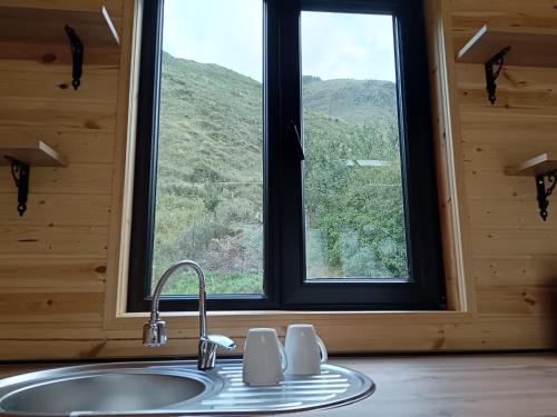 a sink in a room with a large window at My house in Stepantsminda