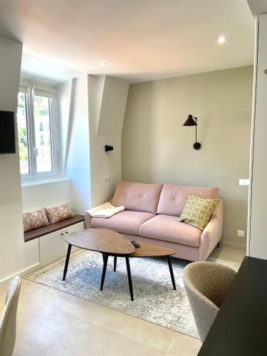 - un salon avec un canapé rose et une table basse dans l'établissement Studio de charme proche gare, à Menton