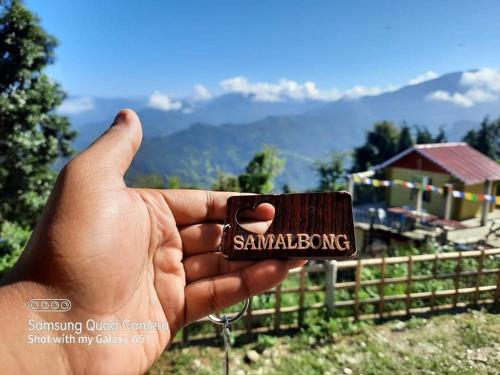 a hand holding a small container with the word sandwich at ATC Samalbong Paharer Bari in Kalimpong