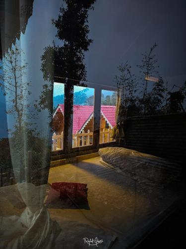 a view of a house seen through a window at ATC Samalbong Paharer Bari in Kalimpong