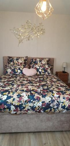 a bedroom with a bed with a colorful comforter at Gîte Guldangel in Hirsingue