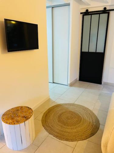 a living room with a television and a stool at Mini villa agosta plage in Albitreccia