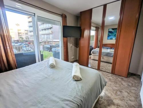 Un dormitorio con una cama grande con toallas. en Spacious apartment in Cabrera de Mar with sea view, en Cabrera de Mar