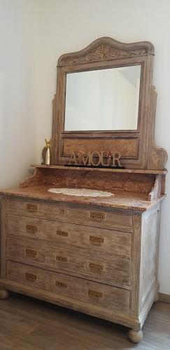 a dresser with a mirror on top of it at Gîte Guldangel in Hirsingue