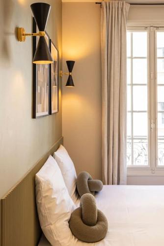 un animal farci assis au-dessus d'un lit dans l'établissement Studio calme et paisible aux porte de Paris, à Le Pré-Saint-Gervais