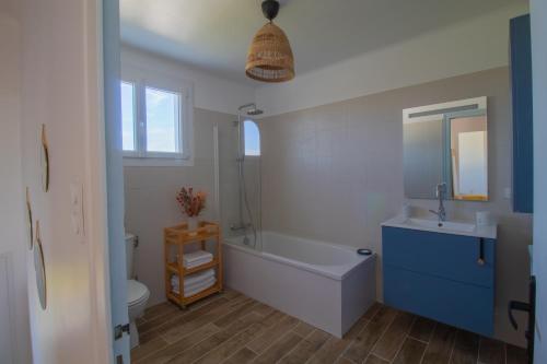 une salle de bain avec une baignoire, un lavabo et des toilettes dans l'établissement Maison familiale La Moutonnière, à Prinquiau