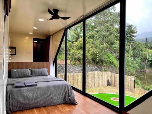 a bedroom with a bed and a large window at The Black & White Box Villa - Genting Highland Foot Area in Bentong