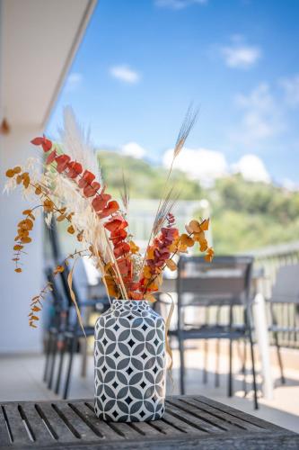 un vase noir et blanc avec des plantes sur une table dans l'établissement Ciel d'Orves - Terrasse Spacieuse- Parking privé, à Nice
