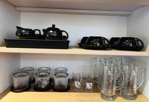 a shelf with glasses and a tea pot on it at The Black & White Box Villa - Genting Highland Foot Area in Bentong