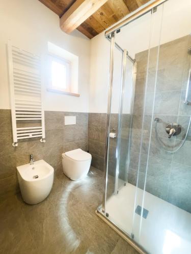 a bathroom with a shower and a toilet and a sink at I tre corvi - Rocca Bianca in Prali