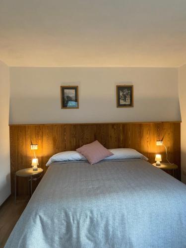 a bedroom with a large bed with two lamps at I tre corvi - Rocca Bianca in Prali