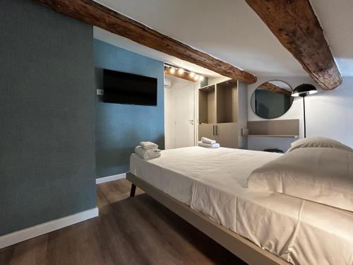 a bedroom with a large bed and a blue wall at Catullo Lounge and Rooms Near The Airport in Caselle