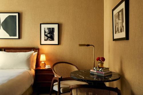 a hotel room with a bed and a table and a bed at Fasano Fifth Avenue I Private Members Club & Hotel in New York