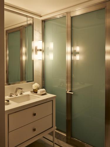 a bathroom with a sink and a glass shower at Fasano Fifth Avenue I Private Members Club & Hotel in New York