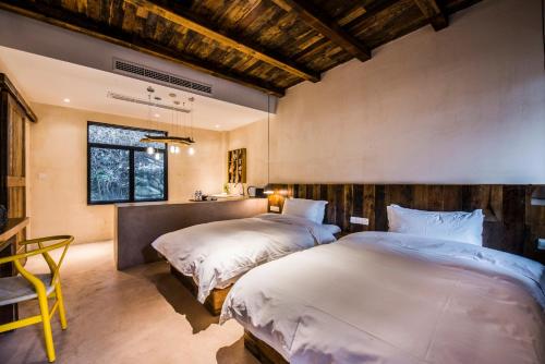 a bedroom with two beds and a table and a chair at 宁波栖霞山居丨森岛 in Shangbao
