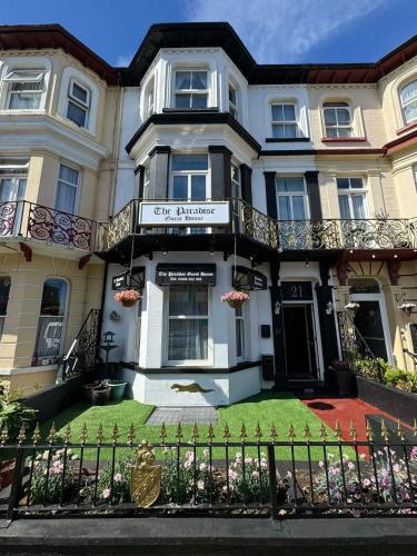 a large white house with a lawn in front of it at The Paradise Guest House in Great Yarmouth