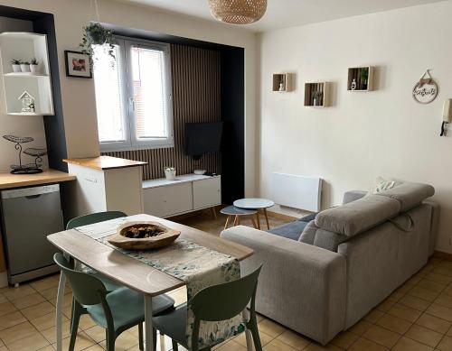 un salon avec un canapé et une table dans l'établissement Appartement cosy, à Cherbourg en Cotentin