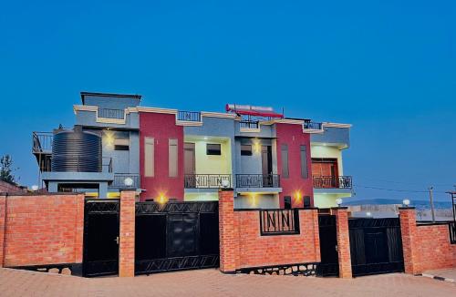 a house with a black gate and a brick fence at N residential suits in Bugesera