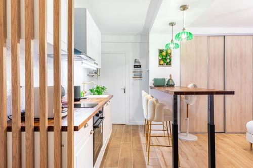 une cuisine avec des armoires blanches et un comptoir en bois dans l'établissement GuestReady - Studio près de République pour Deux, à Paris